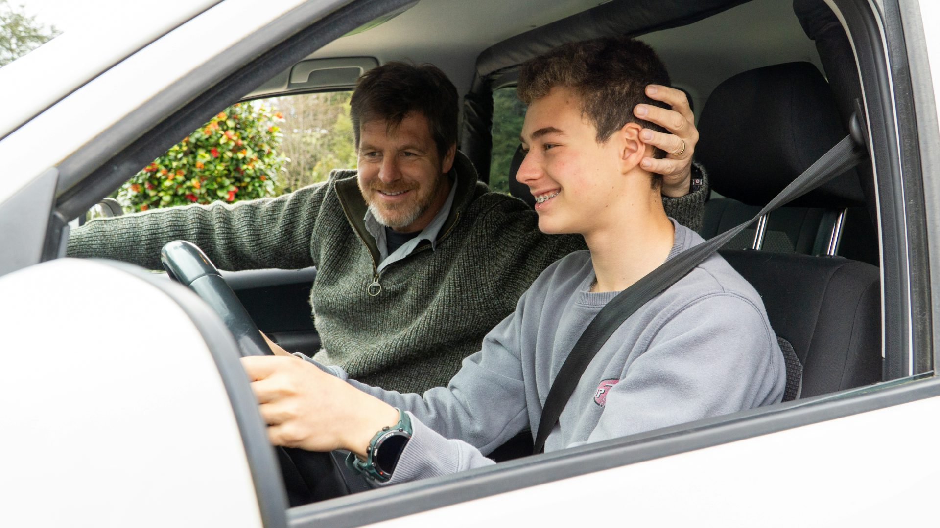 A parent teaching their teen to drive