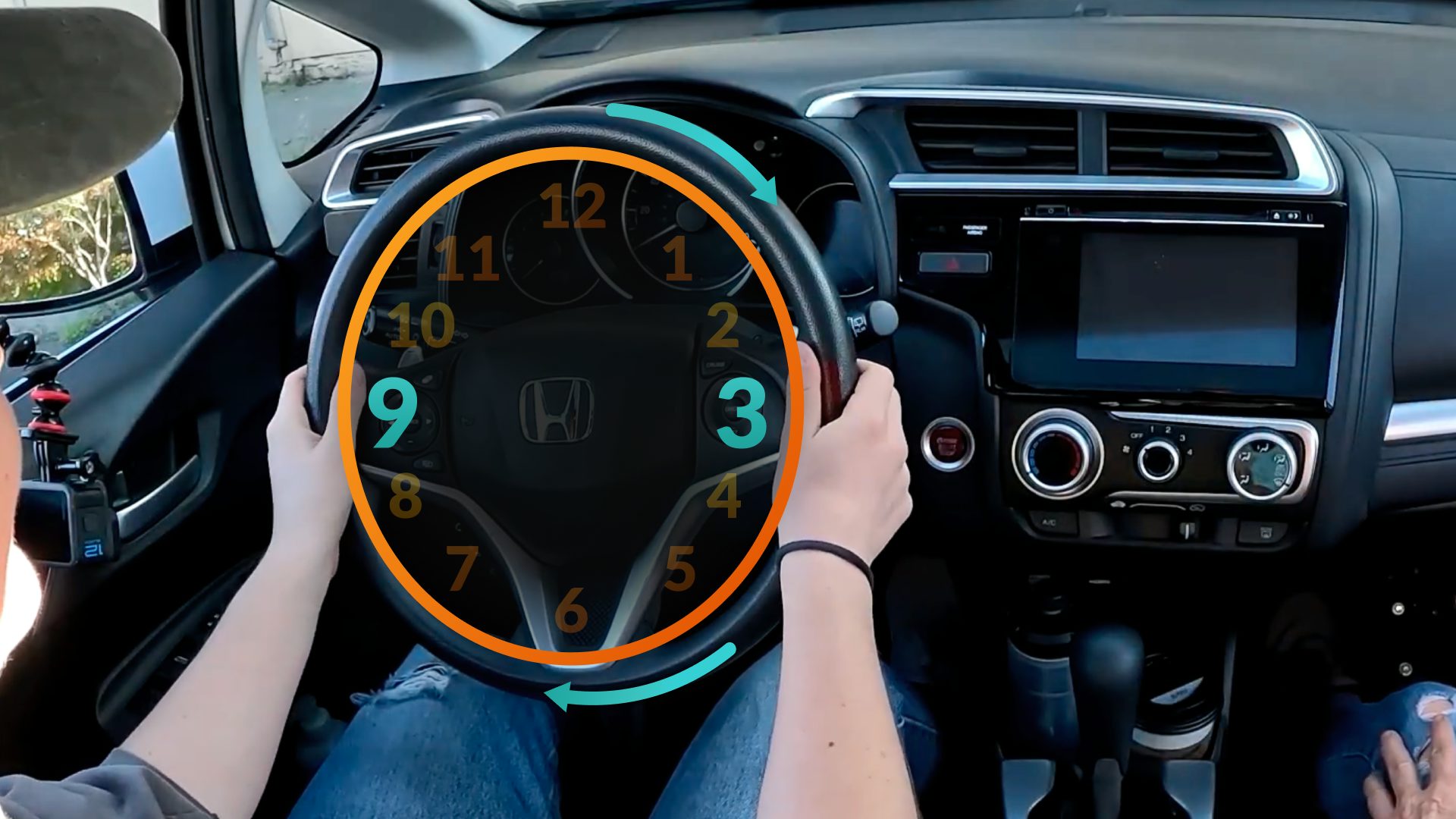 A driver's hands at the 9 and 3 positions on the steering wheel with a clock-face overlay marking the hours.