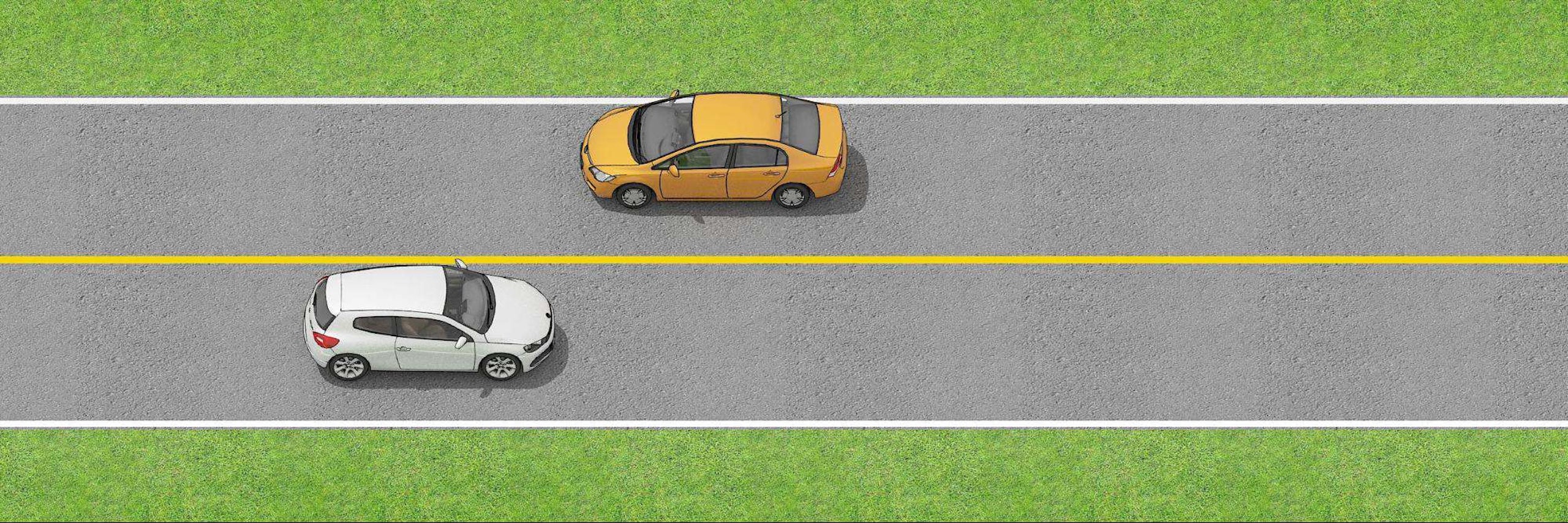 Two vehicles on the road separated by a single solid yellow  line