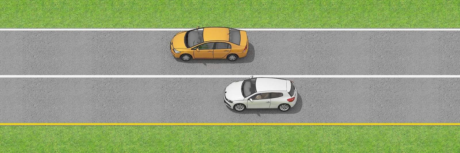Two vehicles traveling in the same directions separated by a single solid white line