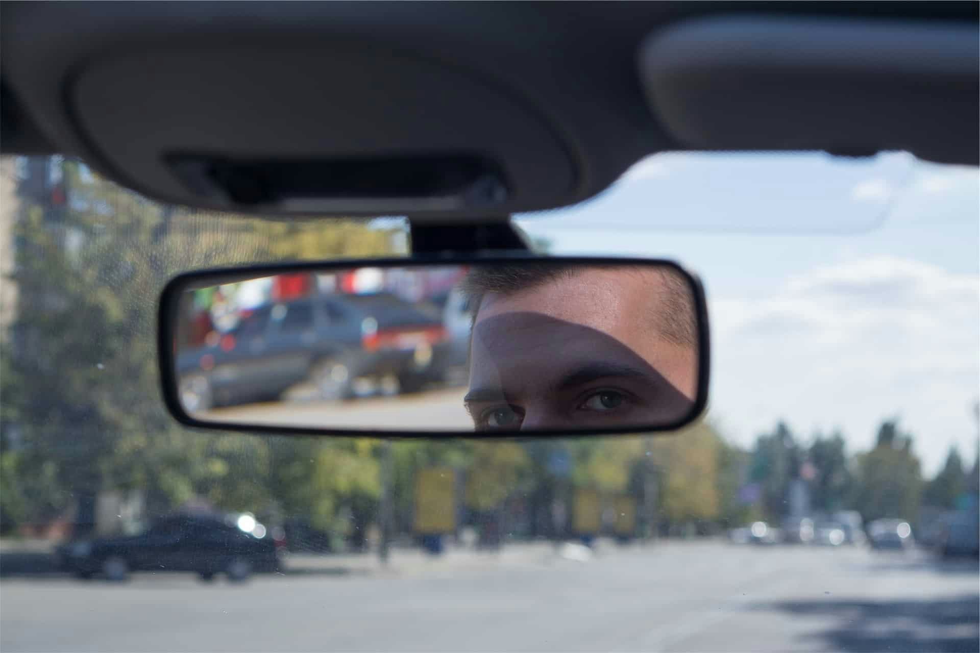 Man checking his rearview mirror while driving