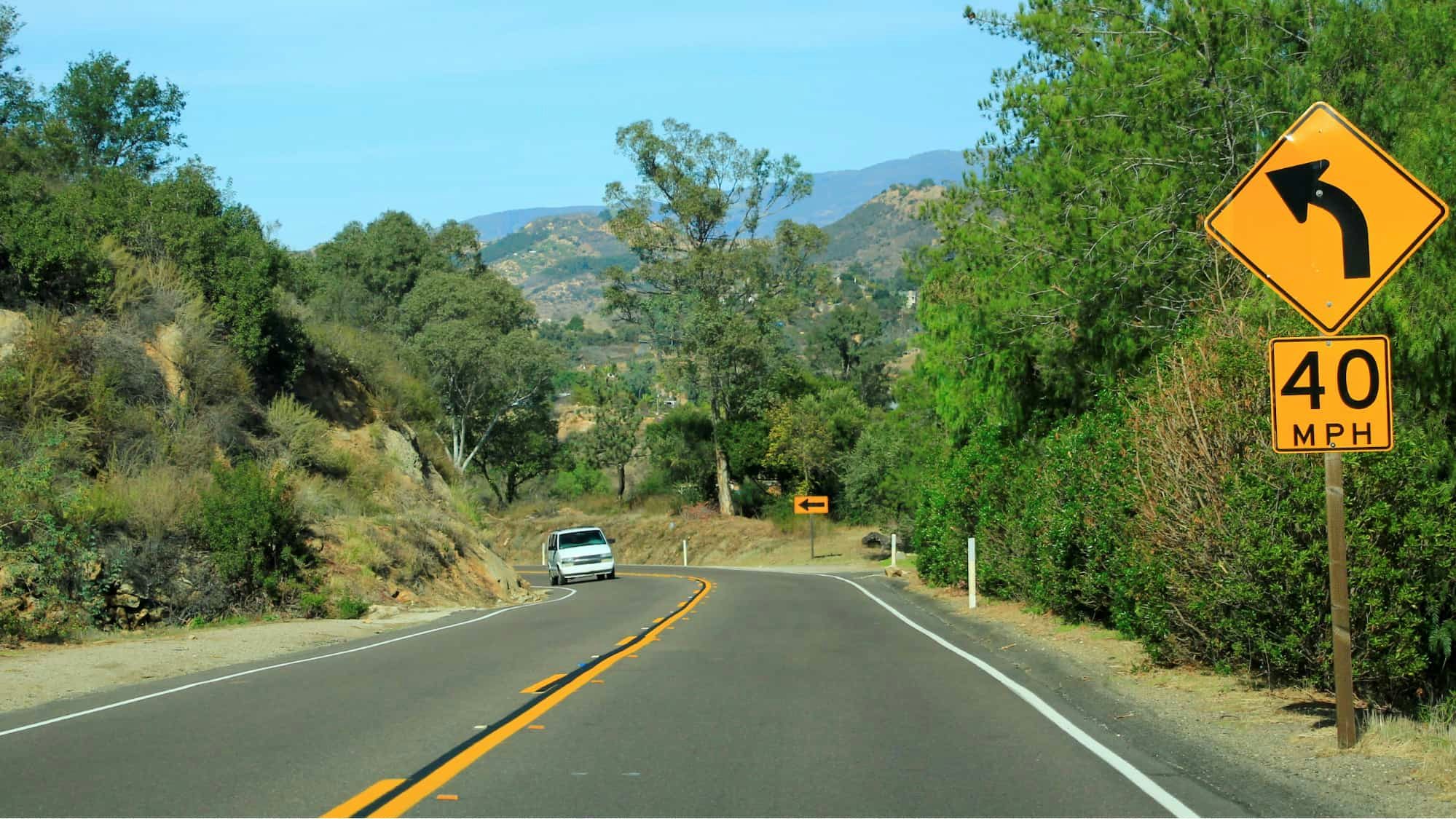 Car driving on a road approaching a curve